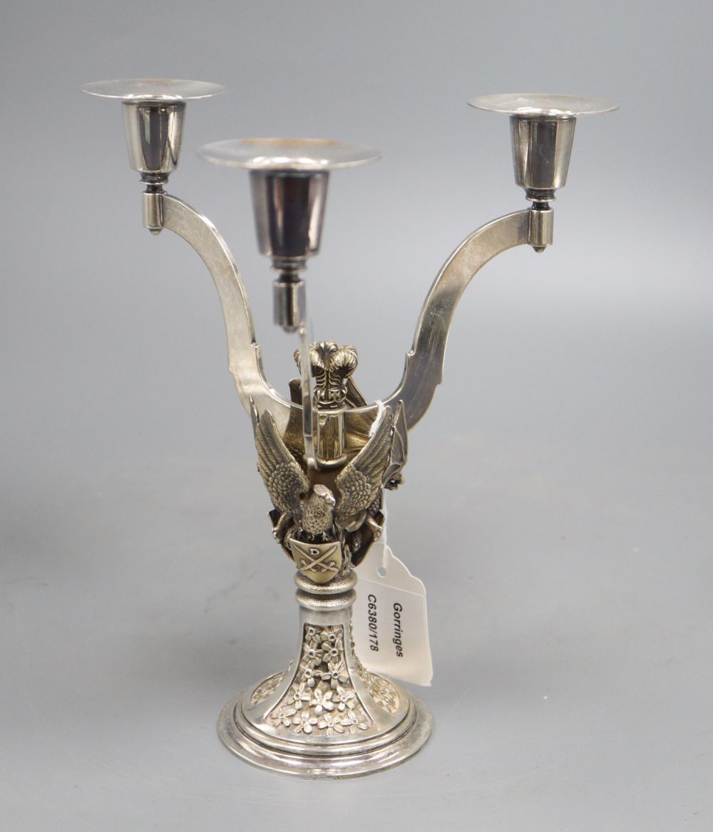 A silver parcel gilt three branch candelabra, shaped arms, on rampant bat,